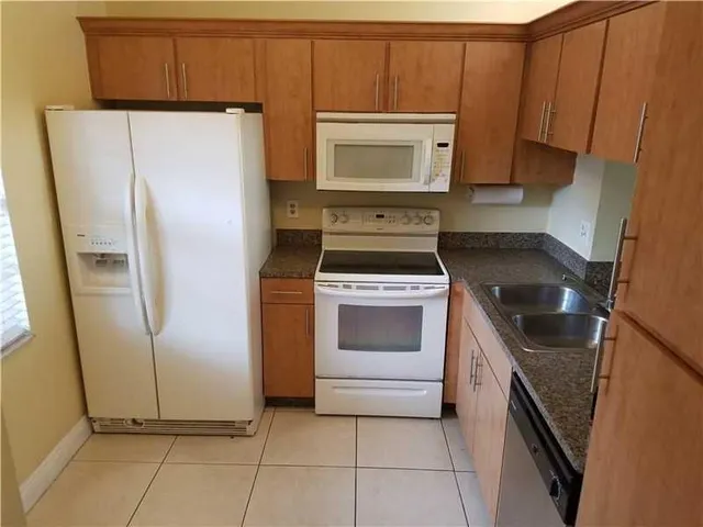 a kitchen with a stove a fridge and a window