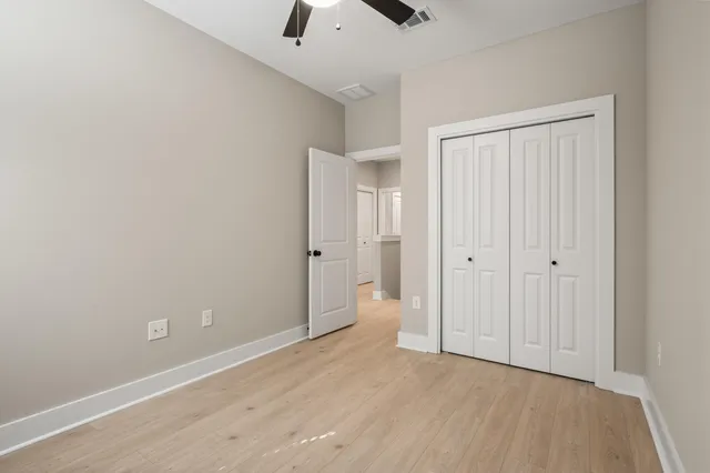 a view of an empty room and chandelier fan