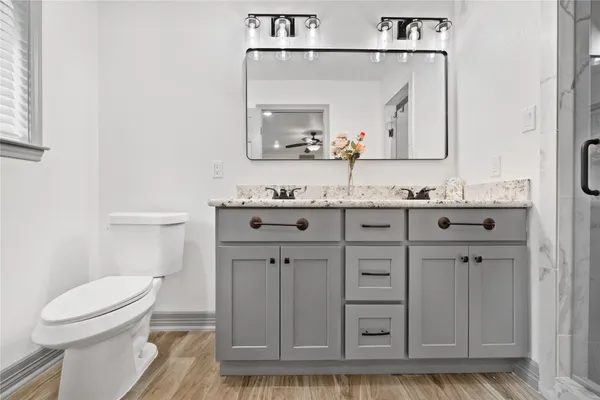 a bathroom with a toilet a sink a vanity and mirror