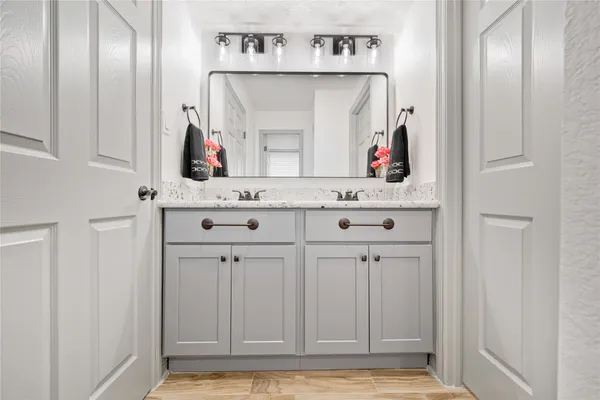 a view of cabinets and entryway with wooden floor