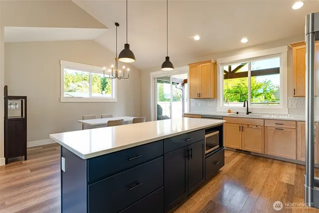 a kitchen with kitchen island granite countertop a sink window and wooden floor