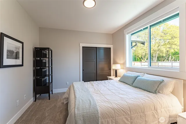 a bedroom with a bed and a large window