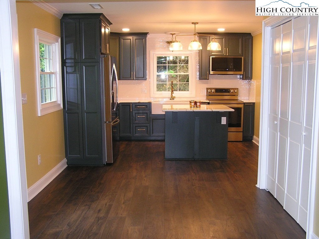 384 New River Heights Road Boone, NC 28607 - Photo 11 of 45 a kitchen with stainless steel appliances kitchen island granite countertop a refrigerator and a stove