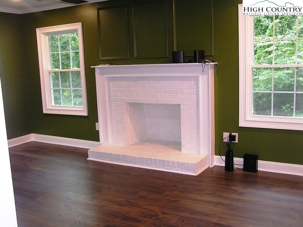 384 New River Heights Road Boone, NC 28607 - Photo 14 of 45 an empty room with wooden floor and a window