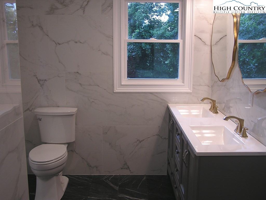 384 New River Heights Road Boone, NC 28607 - Photo 25 of 45 a bathroom with a sink toilet and a mirror