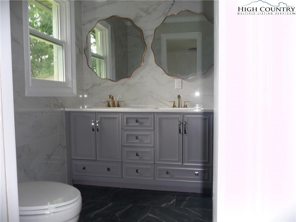 384 New River Heights Road Boone, NC 28607 - Photo 26 of 45 a bathroom with a double vanity sink mirror and toilet