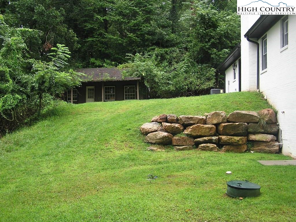 384 New River Heights Road Boone, NC 28607 - Photo 42 of 45 a view of a house with backyard sitting area and garden