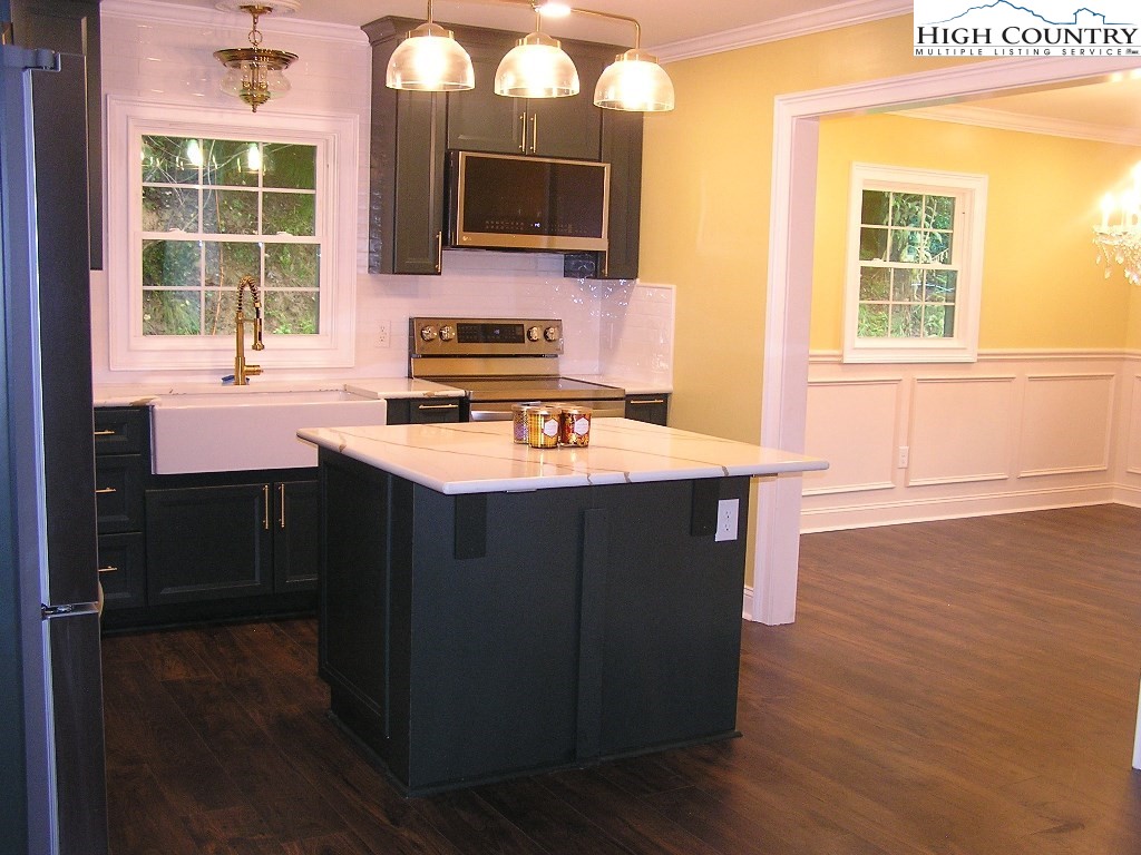 384 New River Heights Road Boone, NC 28607 - Photo 7 of 45 a kitchen with a stove a sink and a microwave