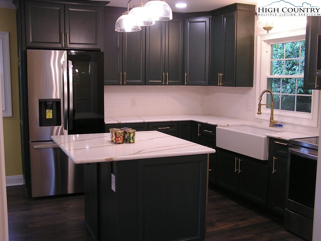 384 New River Heights Road Boone, NC 28607 - Photo 8 of 45 a kitchen with a sink a refrigerator and cabinets