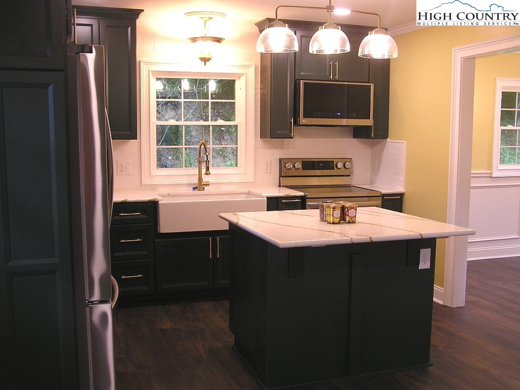 384 New River Heights Road Boone, NC 28607 - Photo 9 of 45 a kitchen with a sink stove and microwave