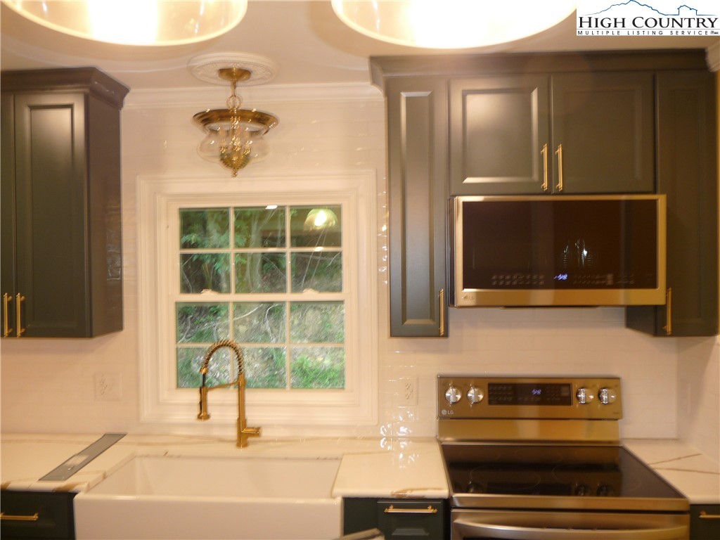 384 New River Heights Road Boone, NC 28607 - Photo 10 of 45 a kitchen with a sink and a stove