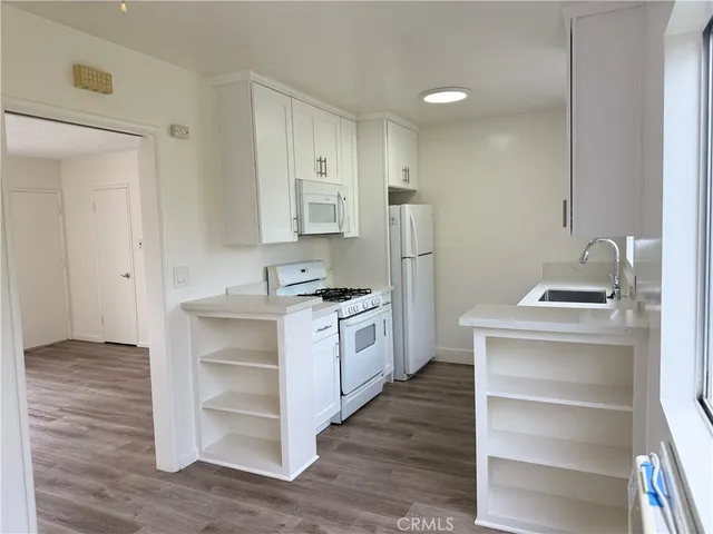 a kitchen with white cabinets and white appliances