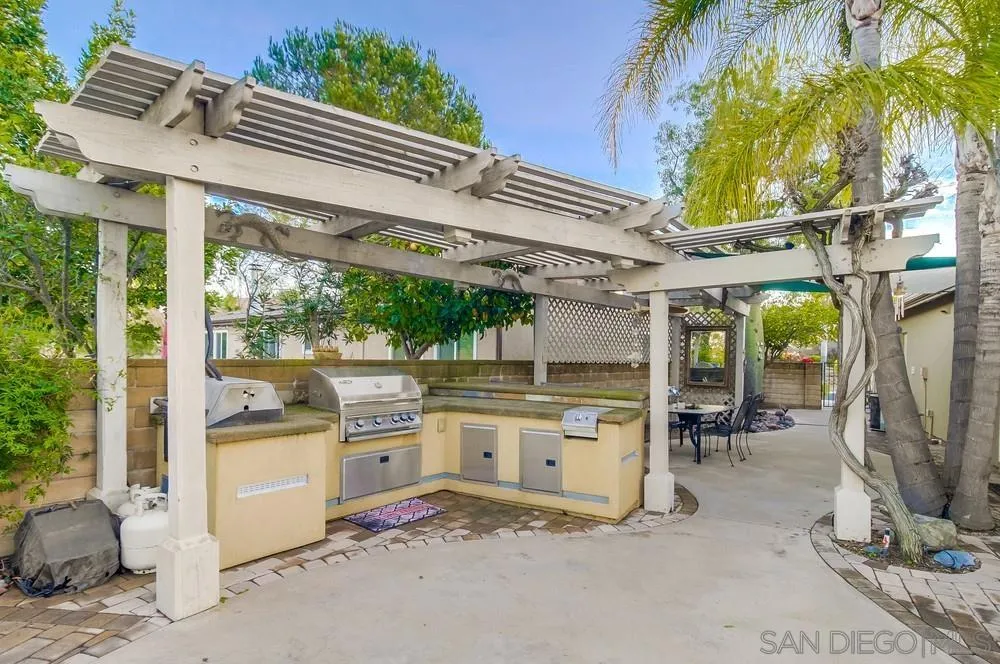2548 Columbine Road Alpine, CA 91901 - Photo 52 of 71 a view of a patio with a table and chairs under an umbrella with a small garden