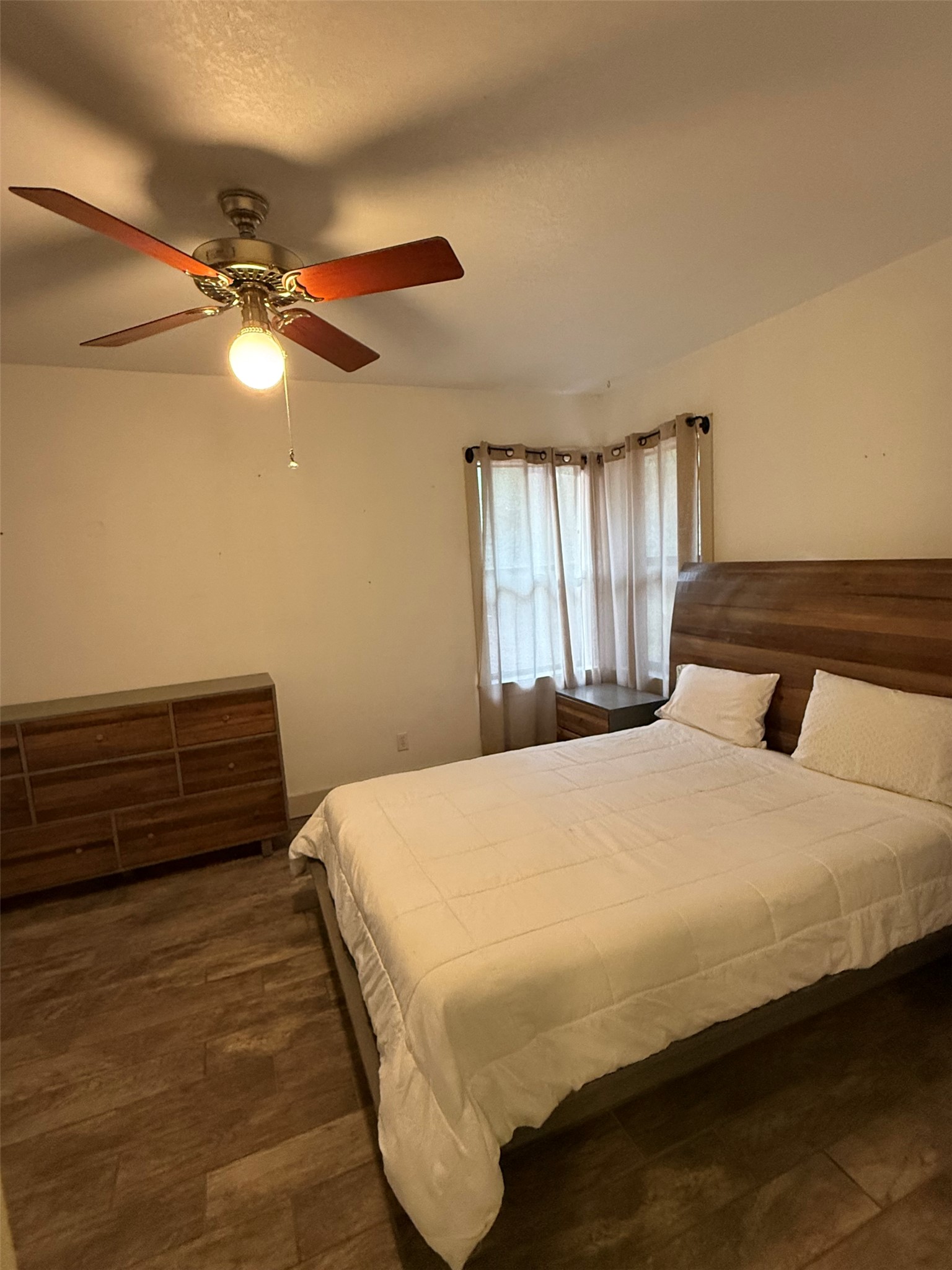 363 Porter Road Bastrop, TX 78602 - Photo 20 of 37 A spacious bedroom features rich wood flooring and a classic bay window setting.