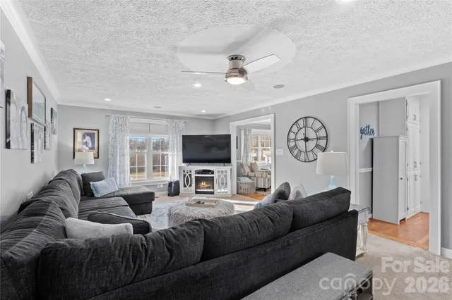 a living room with furniture ceiling fan and a window