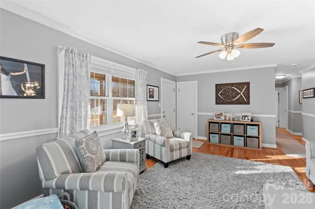 a living room with furniture ceiling fan and a window