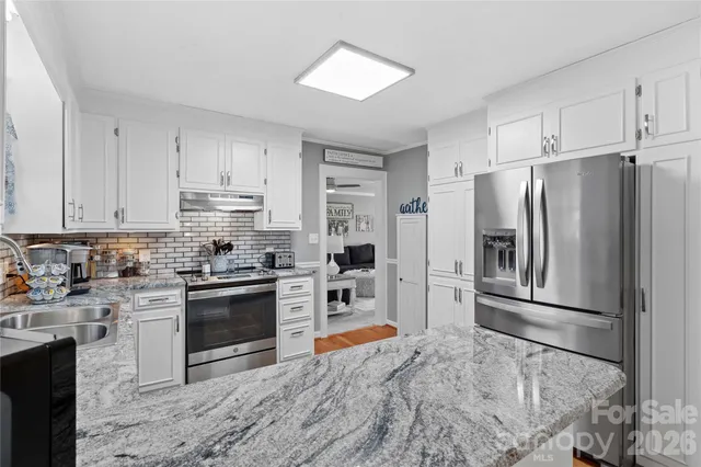 a kitchen with stainless steel appliances granite countertop a refrigerator stove and sink