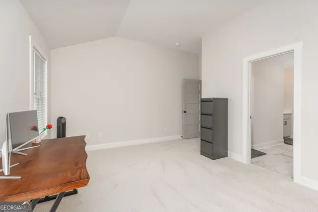 a view of a livingroom with a fireplace a ceiling fan and windows