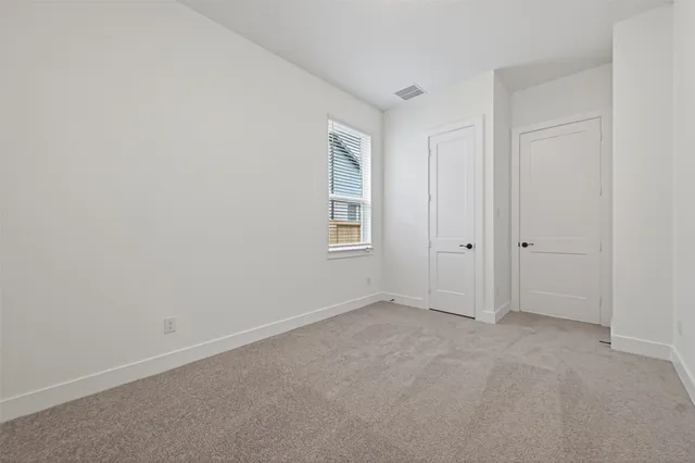 a view of an empty room with windows and closet