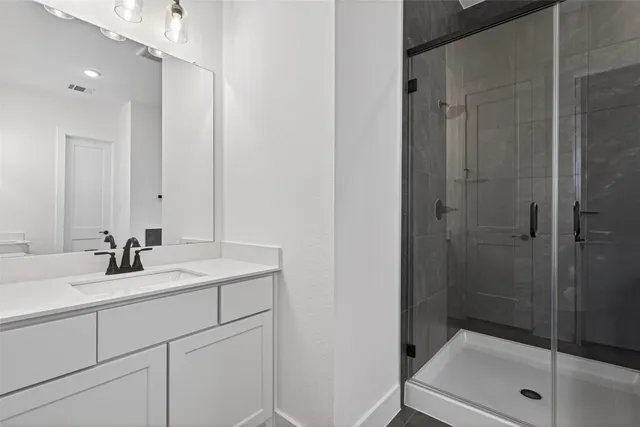 a bathroom with a shower sink and mirror