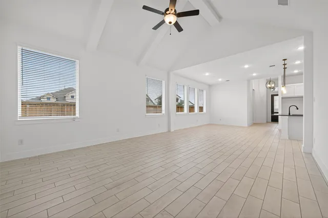 a view of a big room with wooden floor and windows