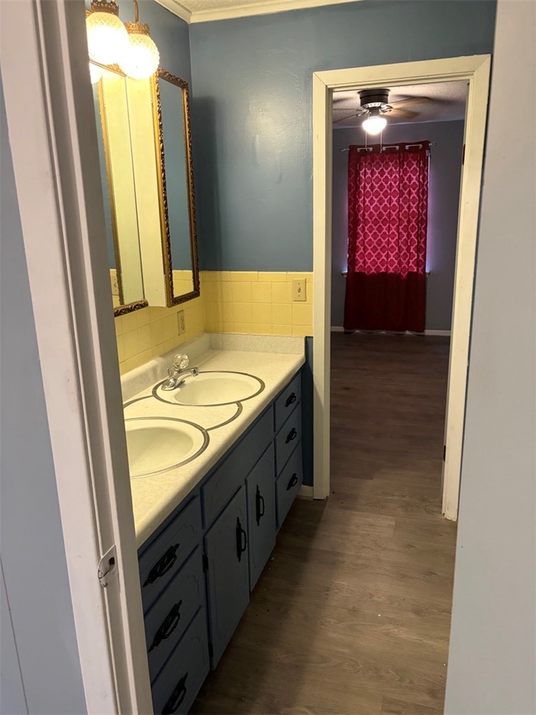 618 Madden Road Jacksonville, AR 72076 - Photo 34 of 34 Double vanity with integrated sinks and blue cabinetry, complemented by a yellow tiled backsplash and overhead vanity lighting
