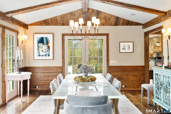 a dining room with furniture a chandelier and wooden floor