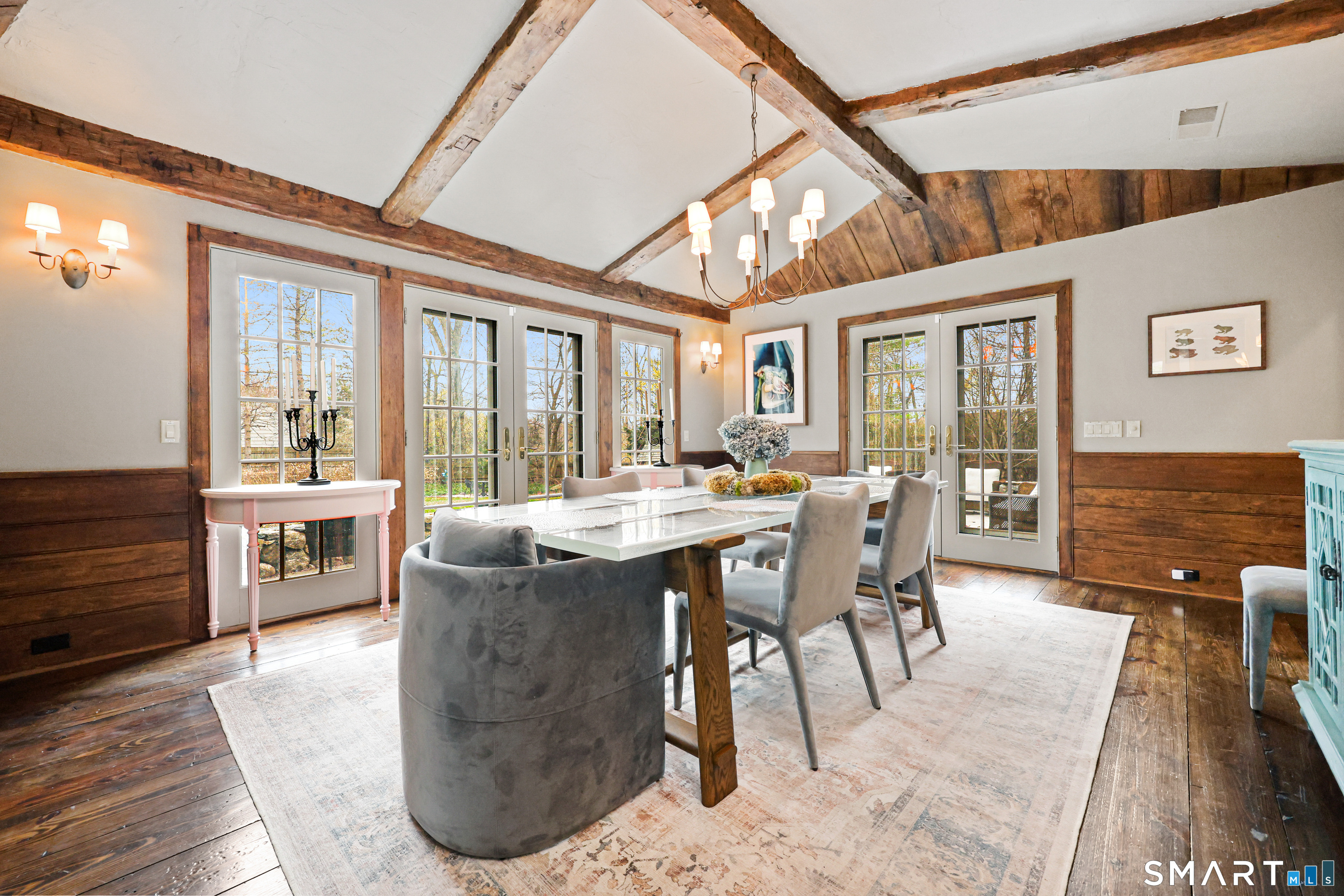 151 Skunk Lane Wilton, CT 06897 - Photo 13 of 39 a view of a dining room with furniture large windows and wooden floor