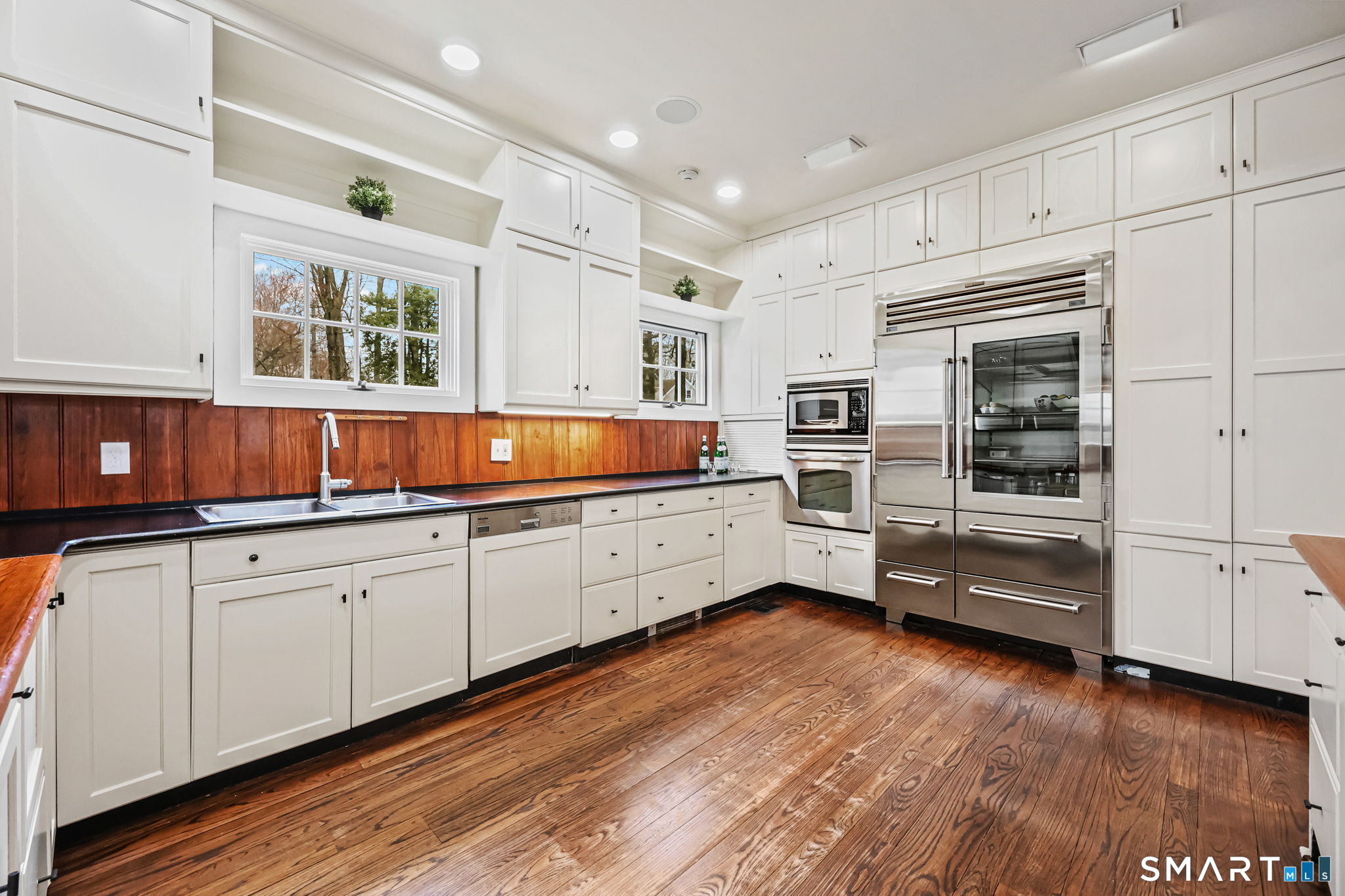 151 Skunk Lane Wilton, CT 06897 - Photo 17 of 39 a kitchen with granite countertop white cabinets and stainless steel appliances