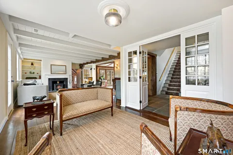 a dining room with furniture a chandelier and wooden floor