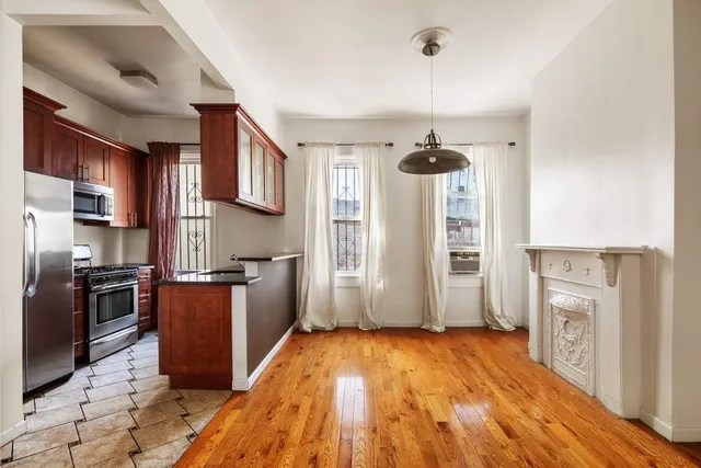 a kitchen with stainless steel appliances granite countertop a refrigerator a stove top oven a sink dishwasher and wooden floor