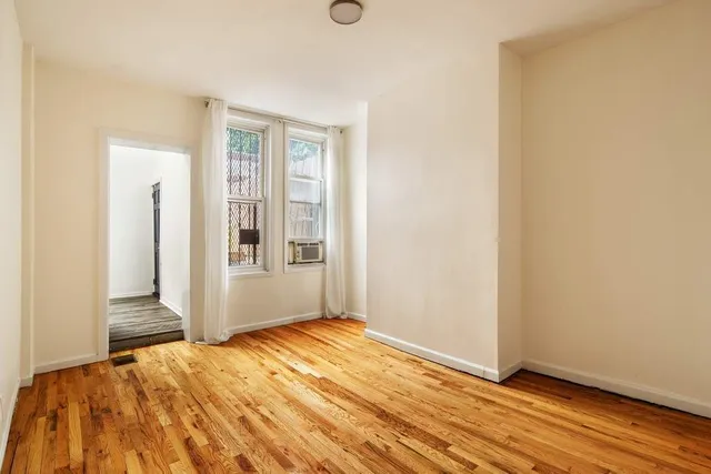 a view of an empty room with wooden floor