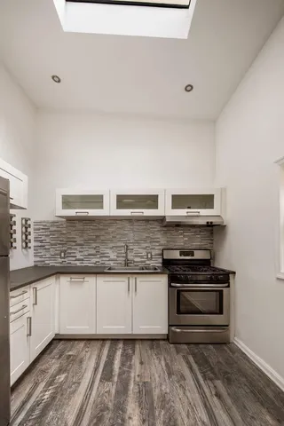 a kitchen with granite countertop a stove and a sink