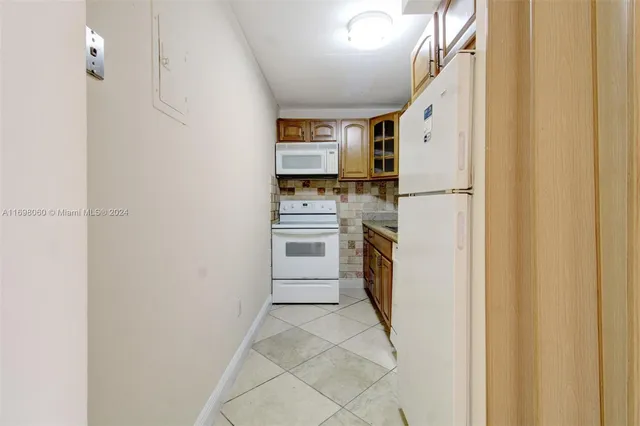 a kitchen with white cabinets and white appliances