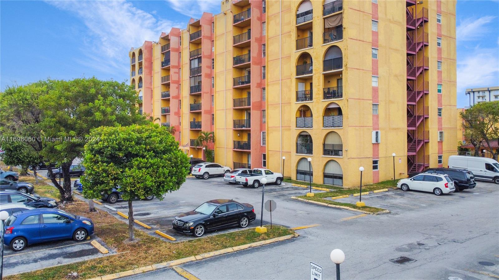 4717 Northwest 7th Street, Unit 60410 Miami, FL 33126 - Photo 20 of 20 a car parked beside a road next to tall buildings