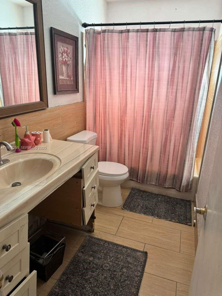 820 Southwest 49th Terrace Margate, FL 33068 - Photo 12 of 15 a bathroom with a sink a toilet and shower curtain