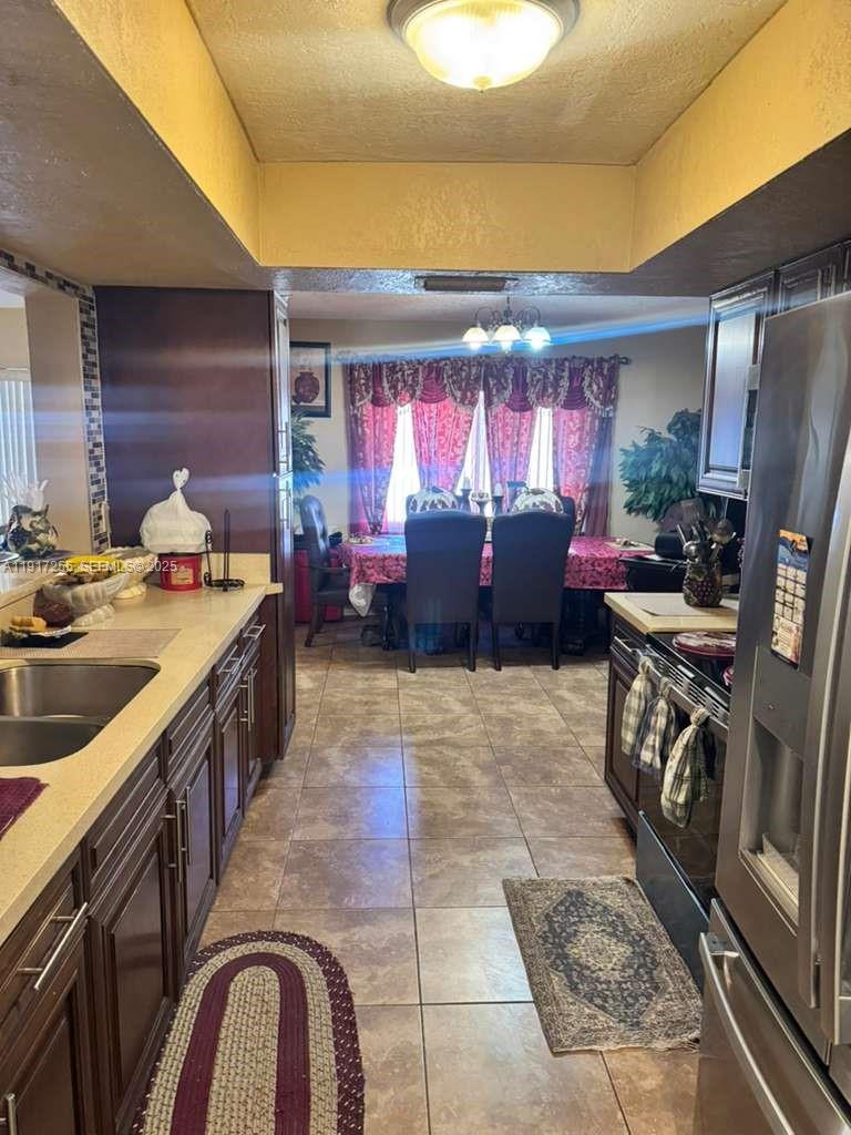 820 Southwest 49th Terrace Margate, FL 33068 - Photo 5 of 15 a kitchen with stainless steel appliances granite countertop a stove a sink and a refrigerator