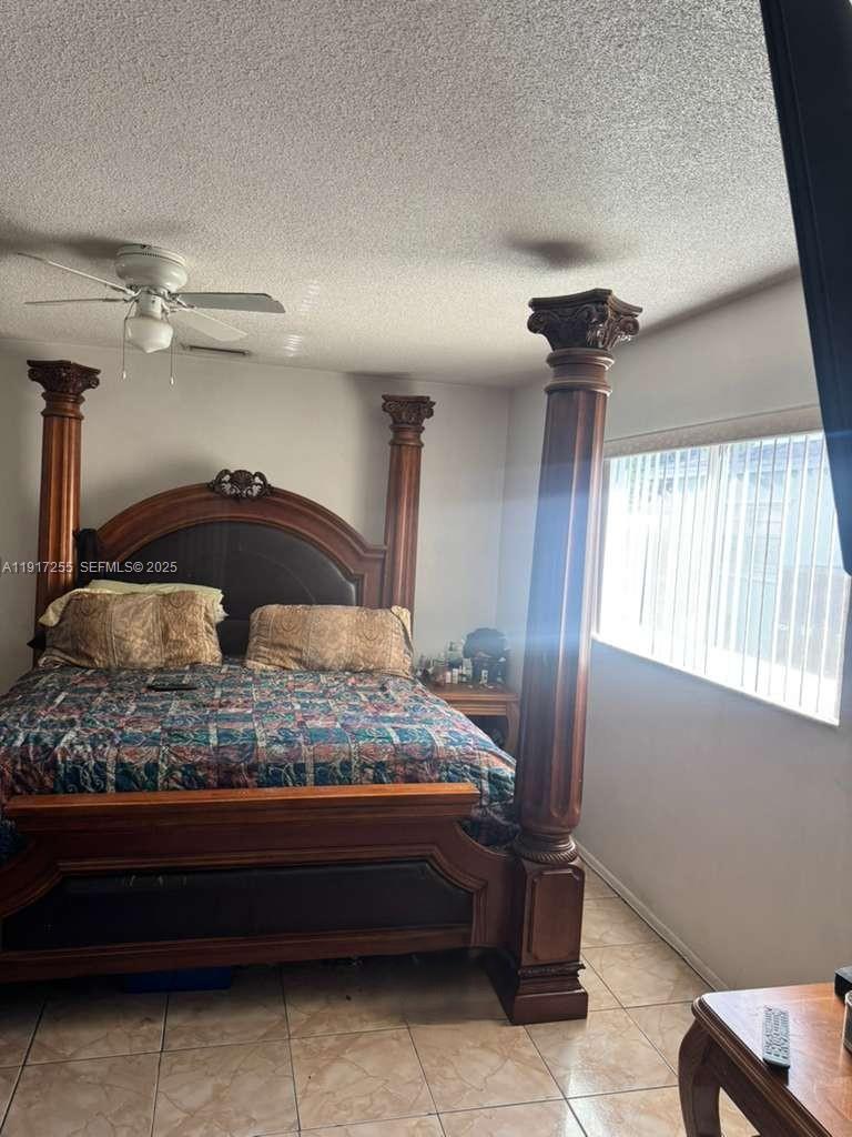 820 Southwest 49th Terrace Margate, FL 33068 - Photo 10 of 15 a bedroom with a bed and a chandelier