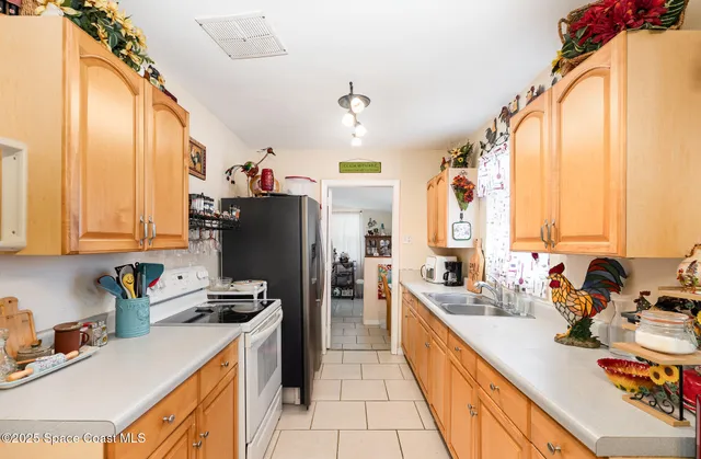 a kitchen with sink a refrigerator and a stove