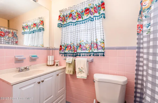a bathroom with a sink vanity mirror and toilet