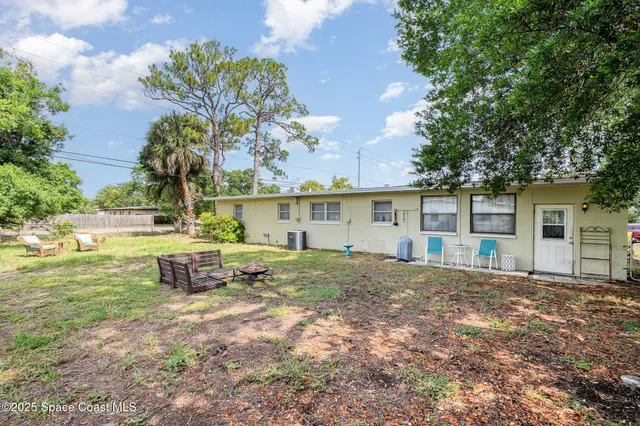 a view of a house with backyard and sitting area