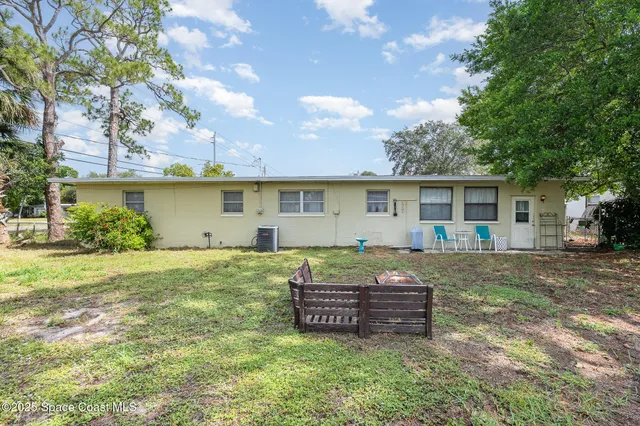 a view of a house with backyard and a tree