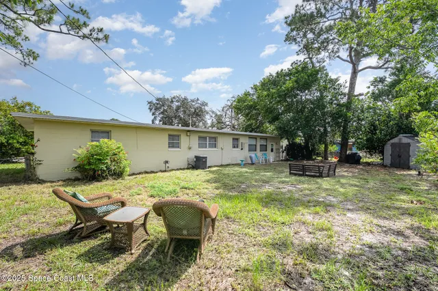 a view of a house with backyard and sitting area