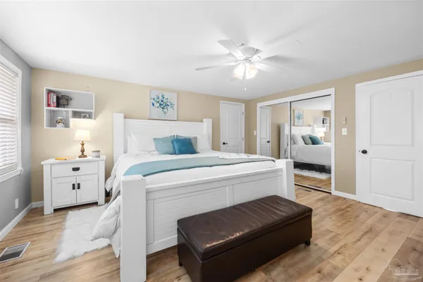 a bedroom with a bed a chandelier and floors