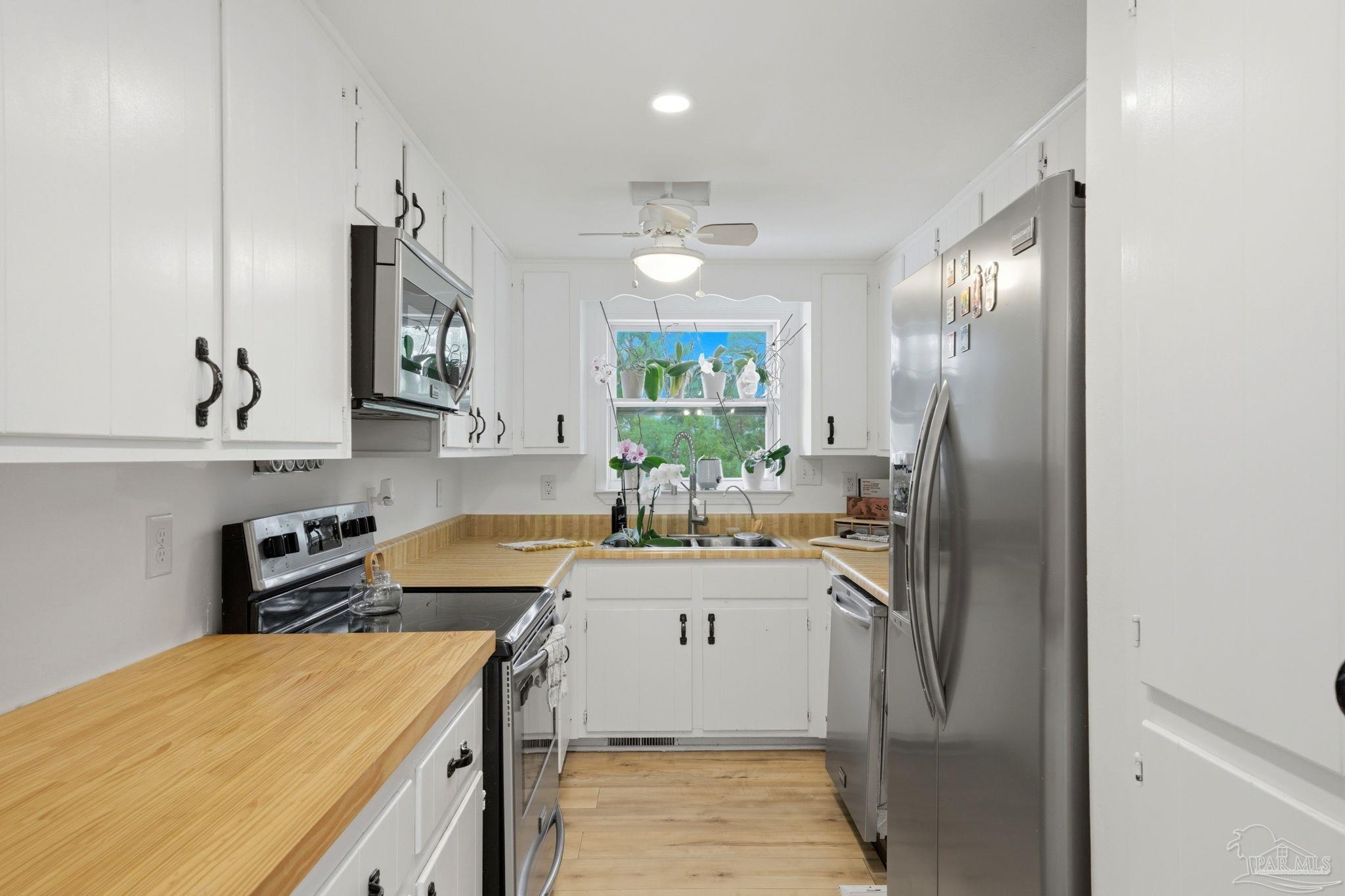889 Dolphin Road Milton, FL 32583 - Photo 14 of 67 a kitchen with stainless steel appliances granite countertop a sink stove and refrigerator