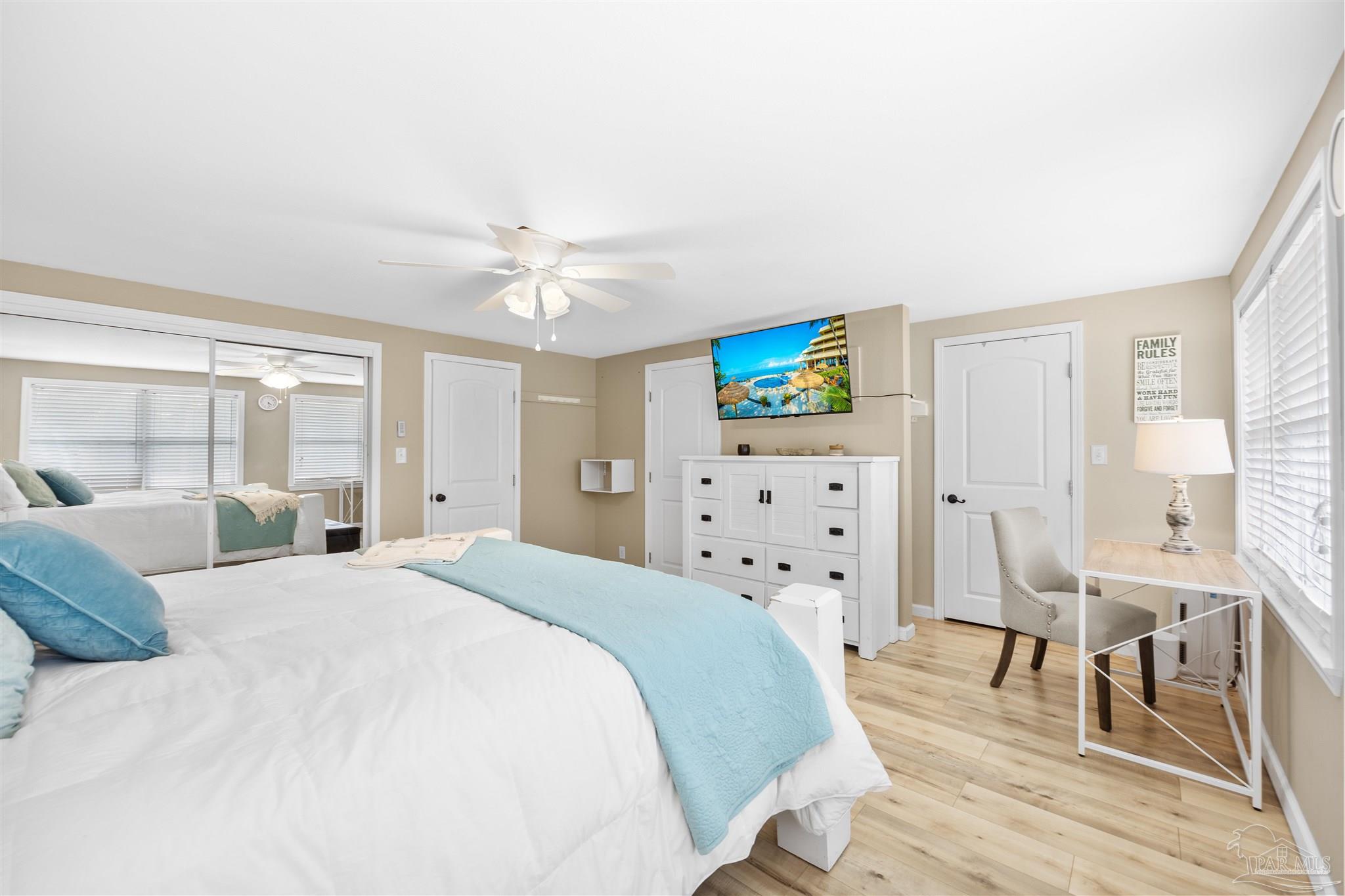889 Dolphin Road Milton, FL 32583 - Photo 18 of 67 a bedroom with a bed a chandelier and floors