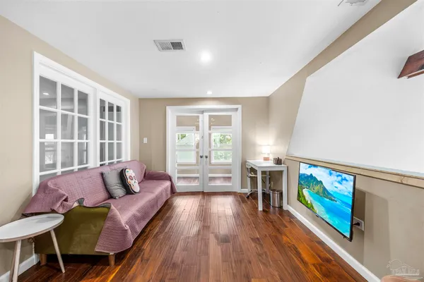 a living room with furniture and a wooden floor