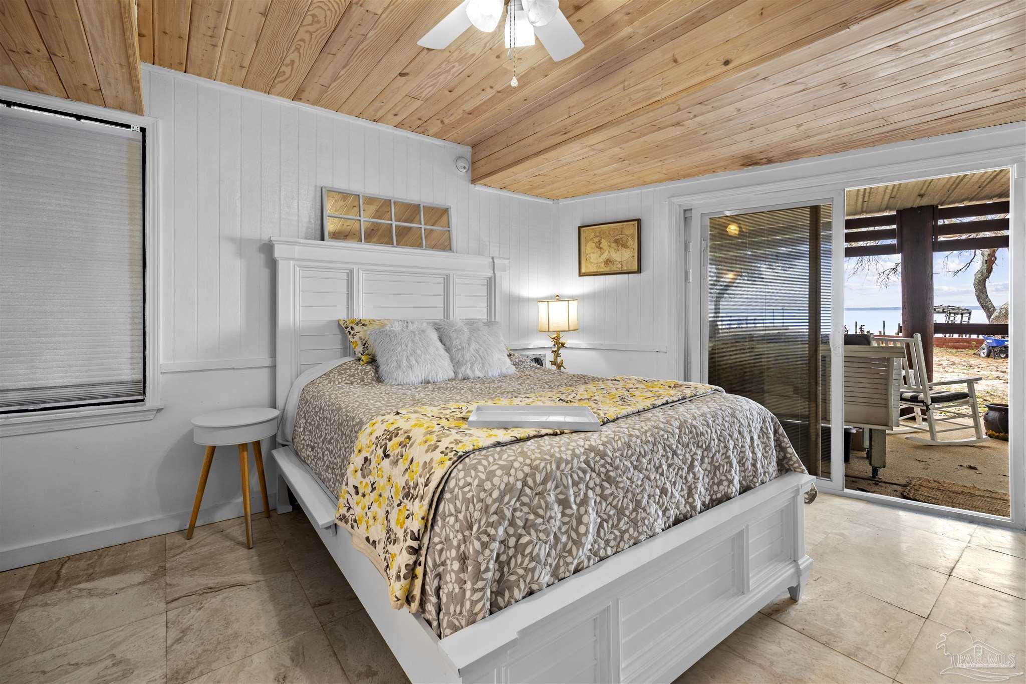 889 Dolphin Road Milton, FL 32583 - Photo 39 of 67 a bedroom with a large bed and a chandelier