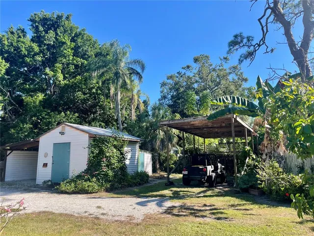 a view of a backyard with table and chairs under an umbrella