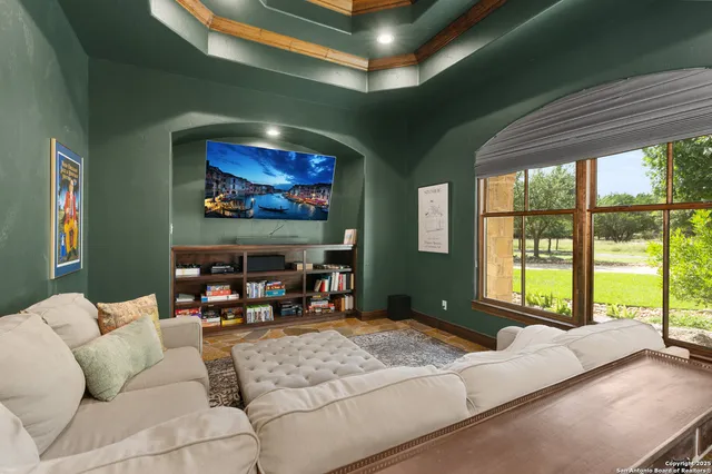 a living room with furniture a floor to ceiling window and a flat screen tv